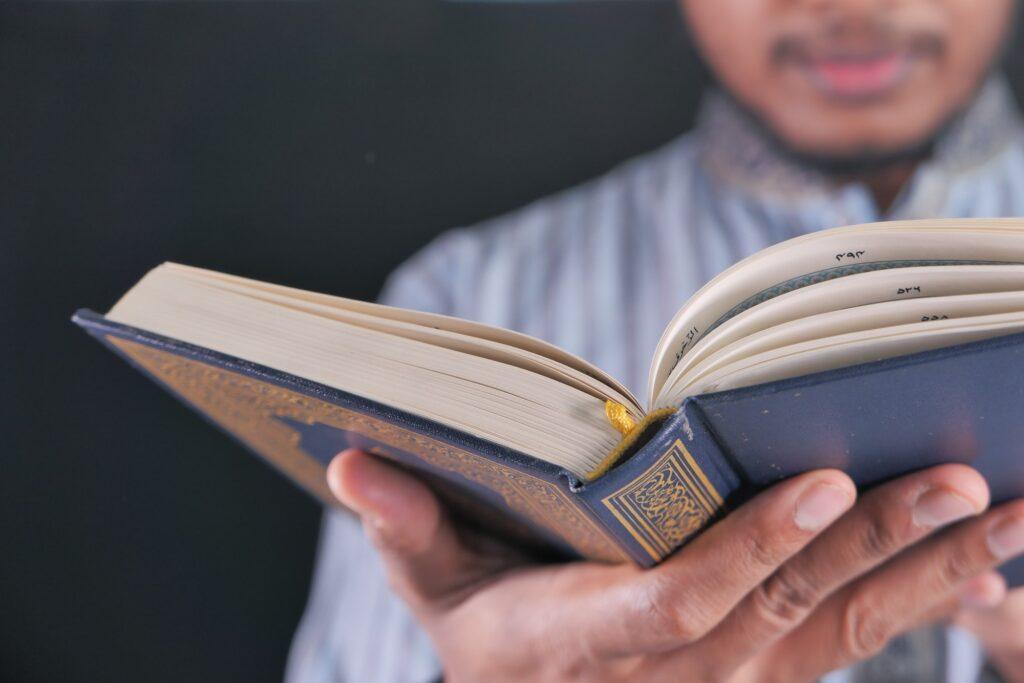 Muslim mans reading quran at night